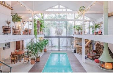 Ngôi nhà màu trắng sở hữu cây xanh và bể bơi bên trong giống như resort nghỉ dưỡng tuyệt đẹp